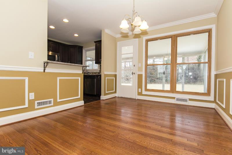 3405 Ripple Road Baltimore, MD 21244 - Photo 8 of 29 a view of a kitchen with a stove wooden cabinets and a floor to ceiling window