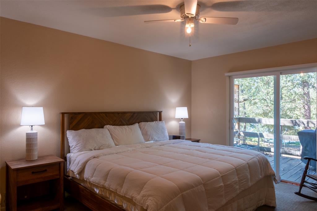 167 Blue Water Point Holly Lake Ranch, TX 75765 - Photo 11 of 27 Wood headboard, ceiling fan, sliding glass door, and exterior deck