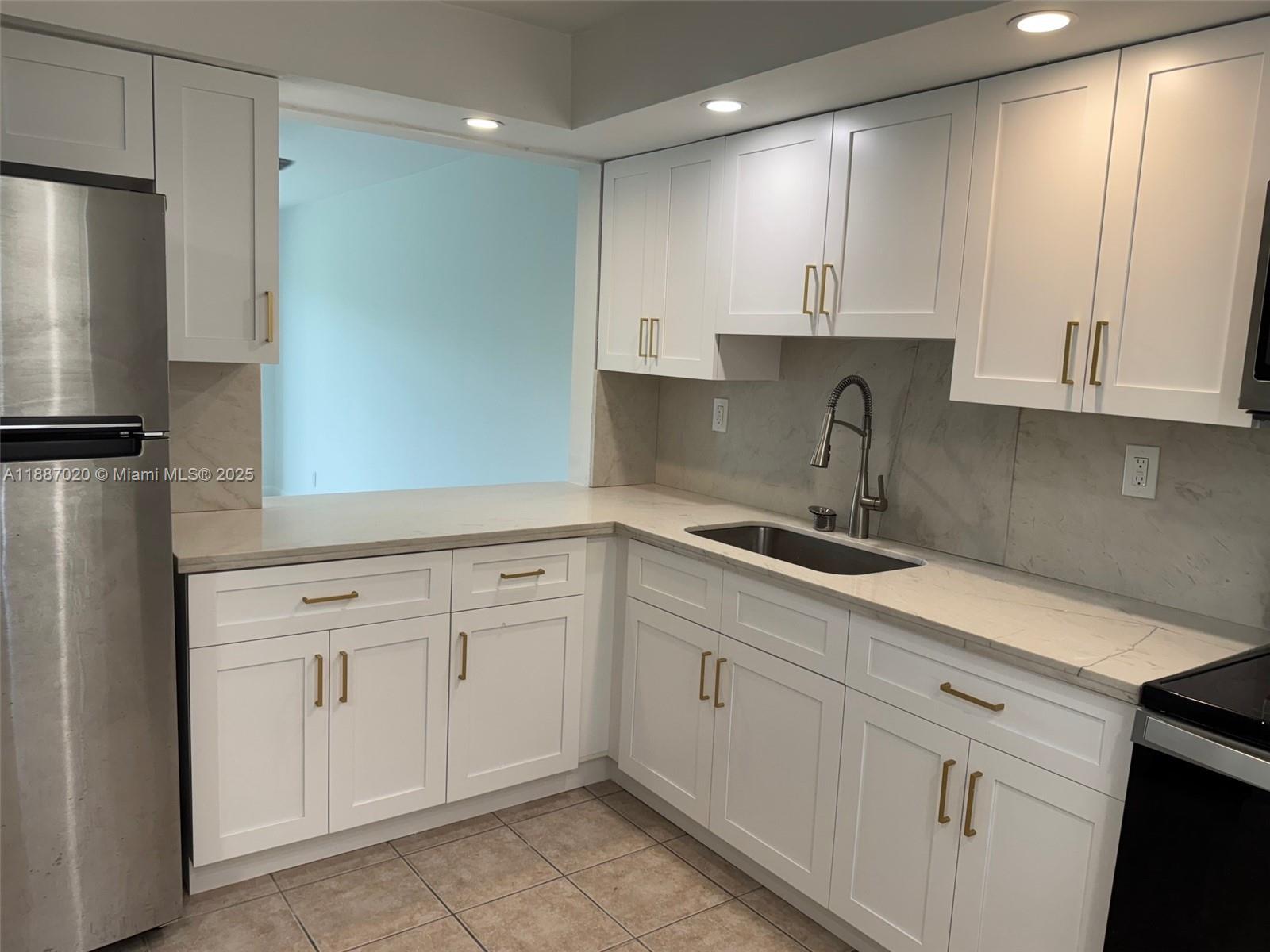 5100 Southwest 90th Avenue, Unit 203 Cooper City, FL 33328 - Photo 2 of 18 a kitchen with white cabinets and refrigerator