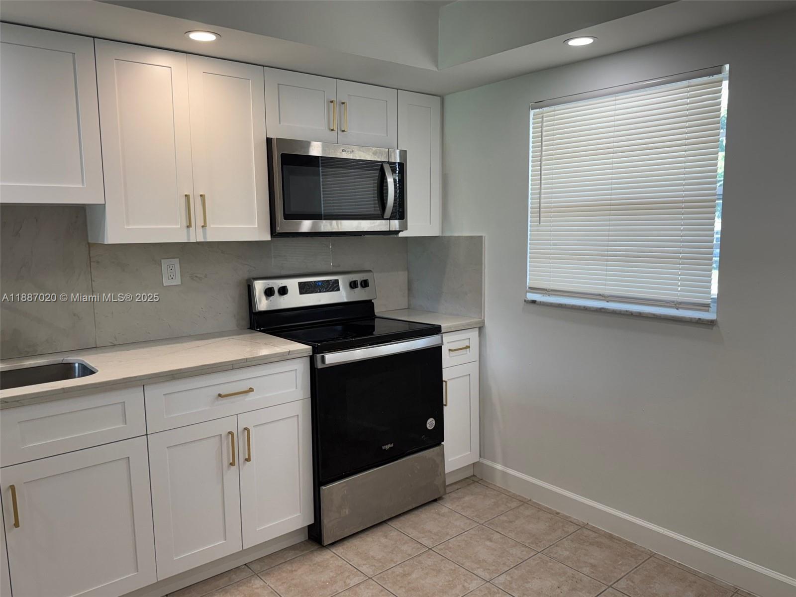5100 Southwest 90th Avenue, Unit 203 Cooper City, FL 33328 - Photo 3 of 18 a kitchen with white cabinets and black appliances