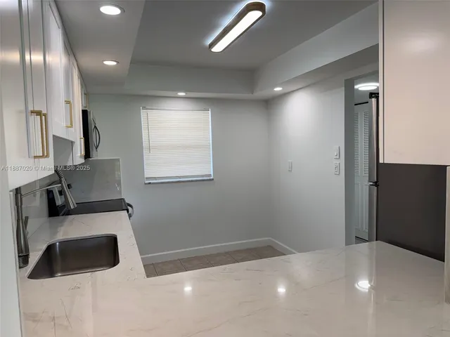 a kitchen with kitchen island a sink stainless steel appliances and cabinets