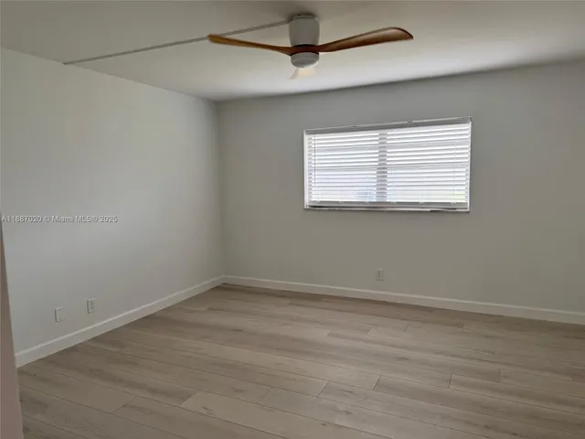 en empty room with wooden floor and windows