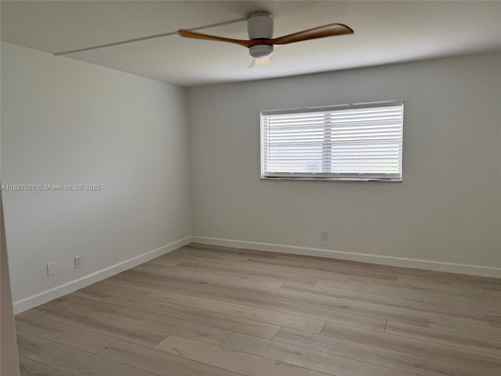 5100 Southwest 90th Avenue, Unit 203 Cooper City, FL 33328 - Photo 7 of 18 en empty room with wooden floor and windows