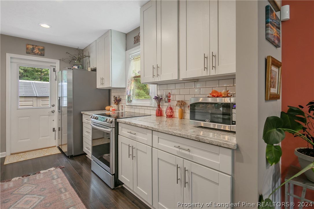 4730 Belford Road Fayetteville, NC 28314 - Photo 11 of 47 a kitchen with stainless steel appliances granite countertop a sink a stove and a refrigerator