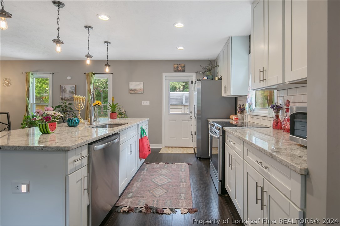 4730 Belford Road Fayetteville, NC 28314 - Photo 12 of 47 a kitchen with kitchen island granite countertop lots of counter top space sink and refrigerator