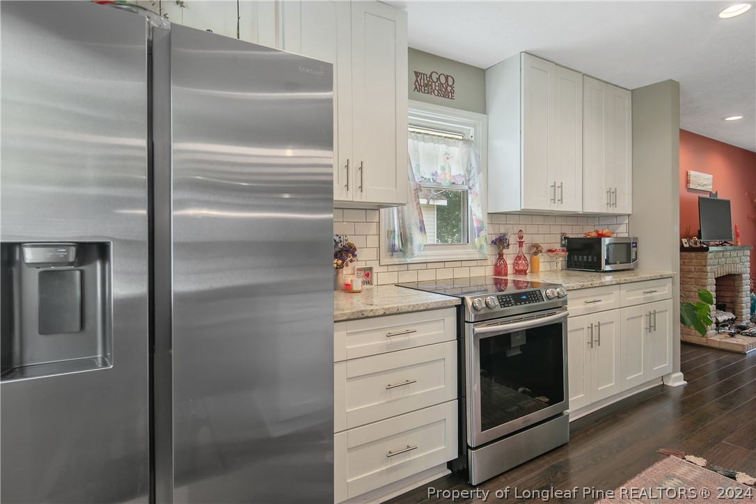 4730 Belford Road Fayetteville, NC 28314 - Photo 14 of 47 a kitchen with stainless steel appliances granite countertop a refrigerator a stove and a sink with wooden floor