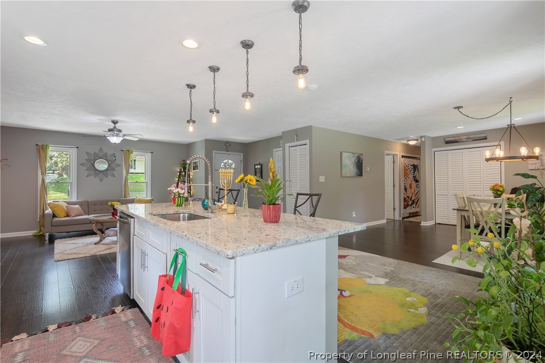 4730 Belford Road Fayetteville, NC 28314 - Photo 16 of 47 a large kitchen with kitchen island a counter top space a sink appliances and living room view