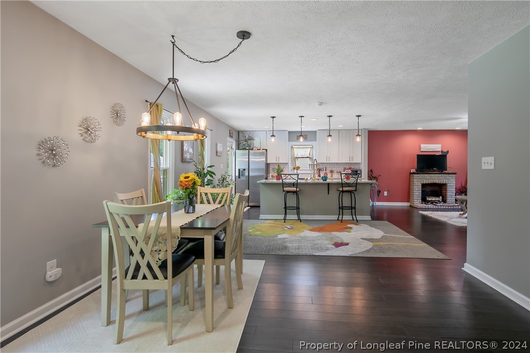 4730 Belford Road Fayetteville, NC 28314 - Photo 24 of 47 a view of a dining room with furniture a chandelier and wooden floor