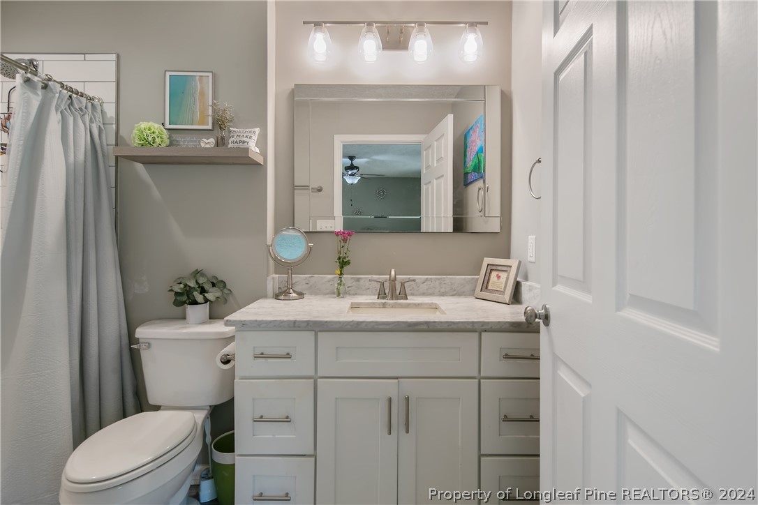 4730 Belford Road Fayetteville, NC 28314 - Photo 30 of 47 a bathroom with a sink vanity mirror and toilet