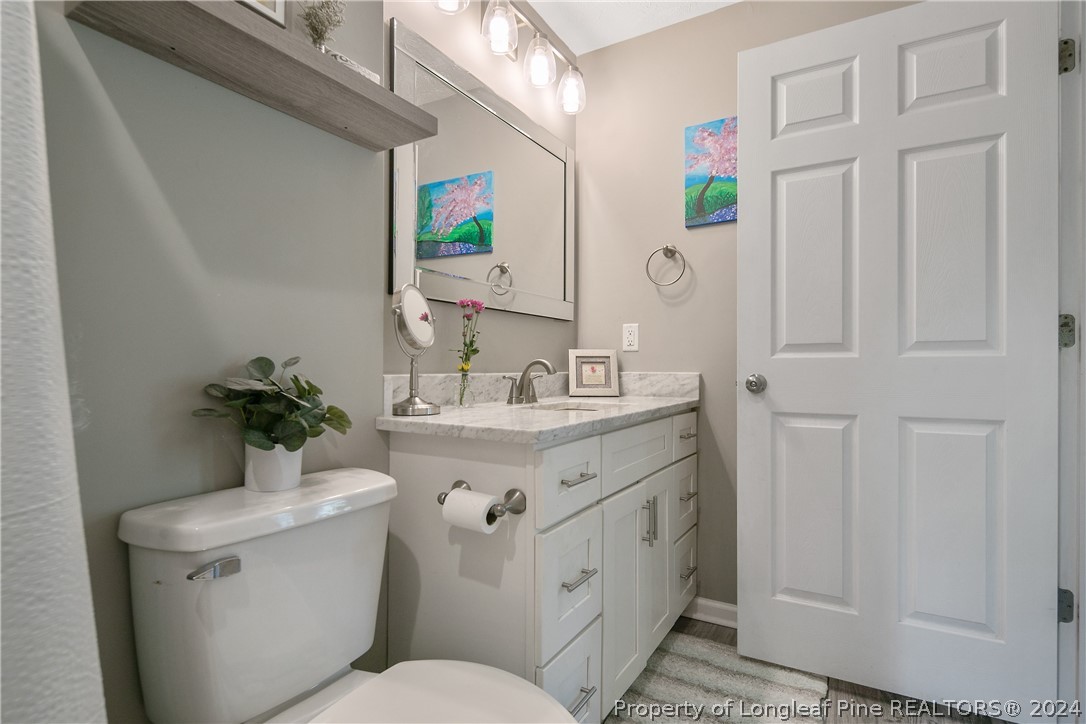 4730 Belford Road Fayetteville, NC 28314 - Photo 31 of 47 a bathroom with a toilet sink and mirror