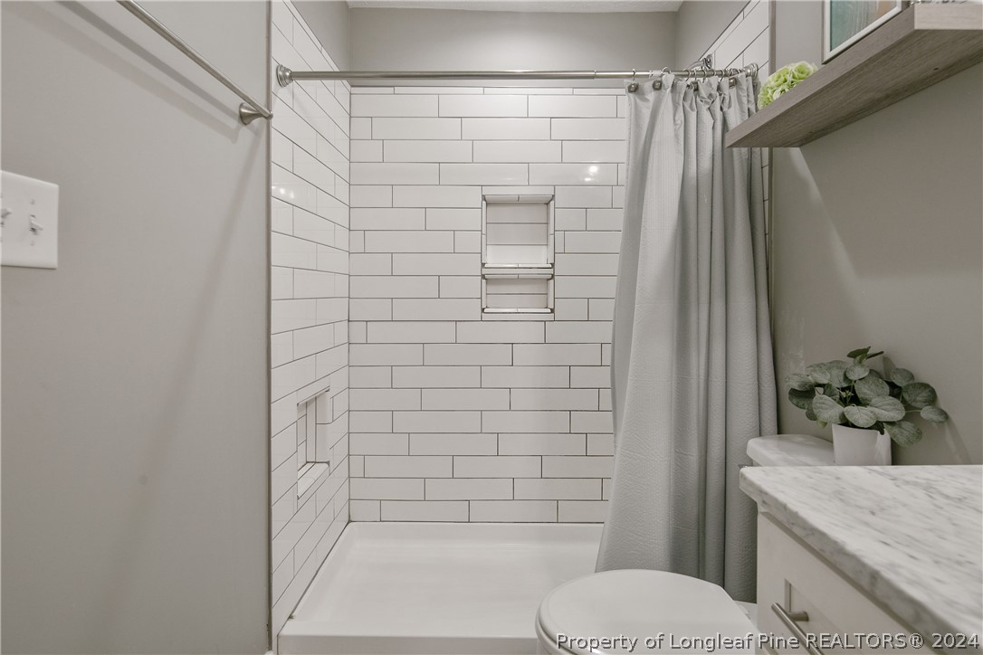 4730 Belford Road Fayetteville, NC 28314 - Photo 32 of 47 a bathroom with a granite countertop shower and a toilet