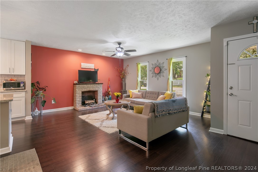 4730 Belford Road Fayetteville, NC 28314 - Photo 7 of 47 a living room with furniture a fireplace and a flat screen tv