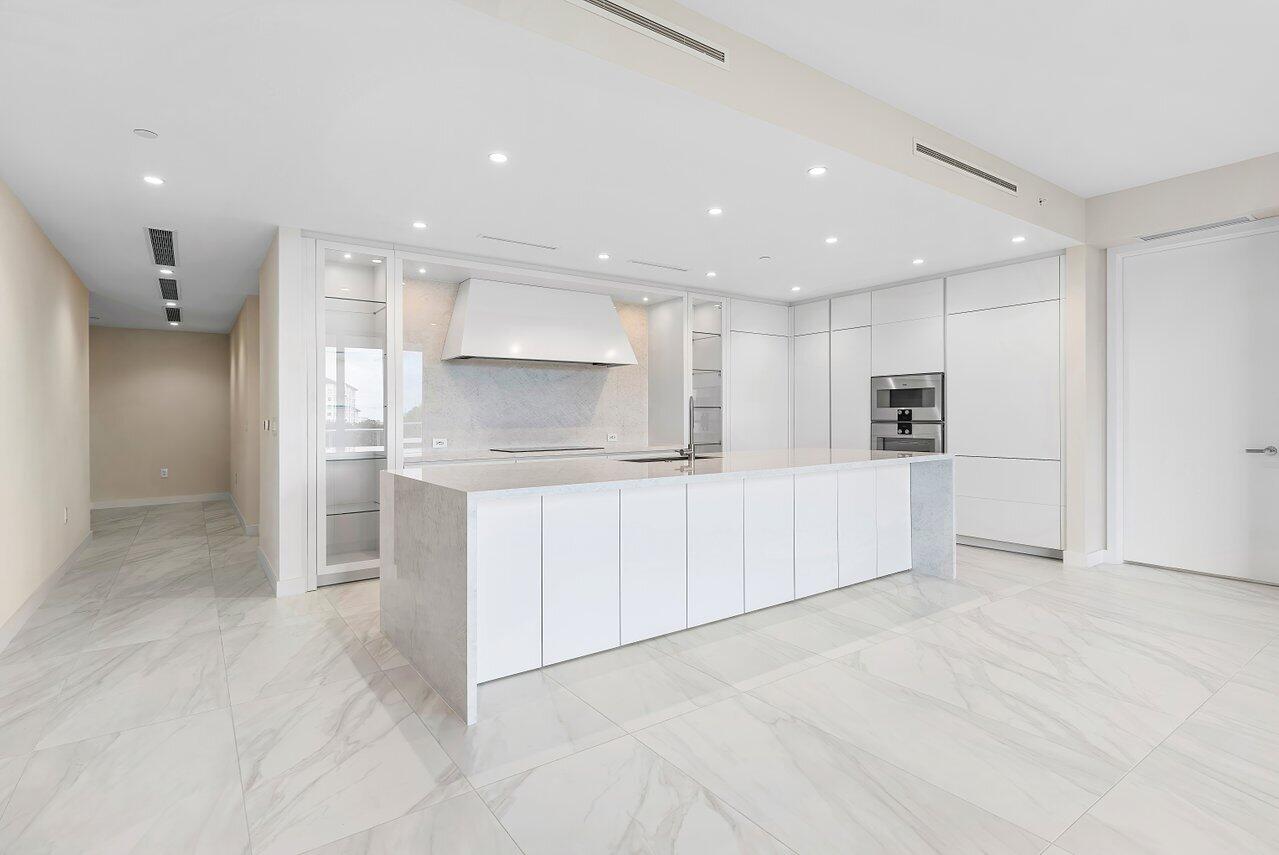 220 Southeast Mizner Boulevard, Unit 506 Boca Raton, FL 33432 - Photo 11 of 64 a kitchen with white cabinets and refrigerator