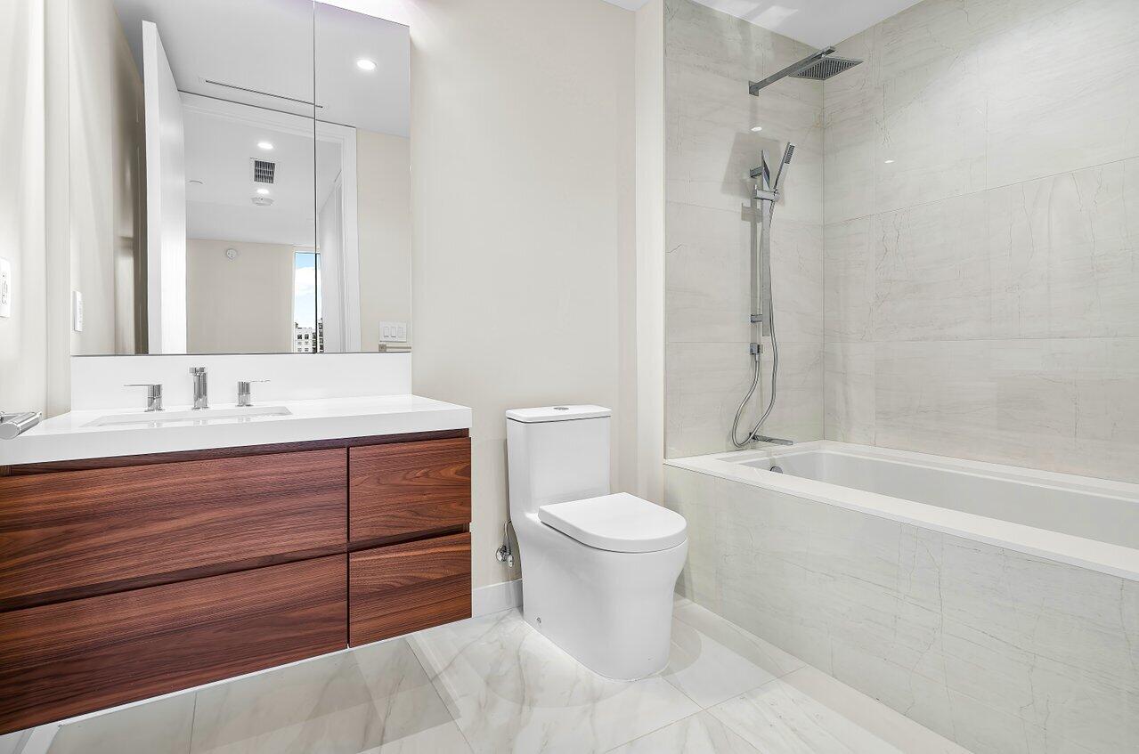 220 Southeast Mizner Boulevard, Unit 506 Boca Raton, FL 33432 - Photo 29 of 64 a bathroom with a bathtub shower sink mirror vanity and toilet