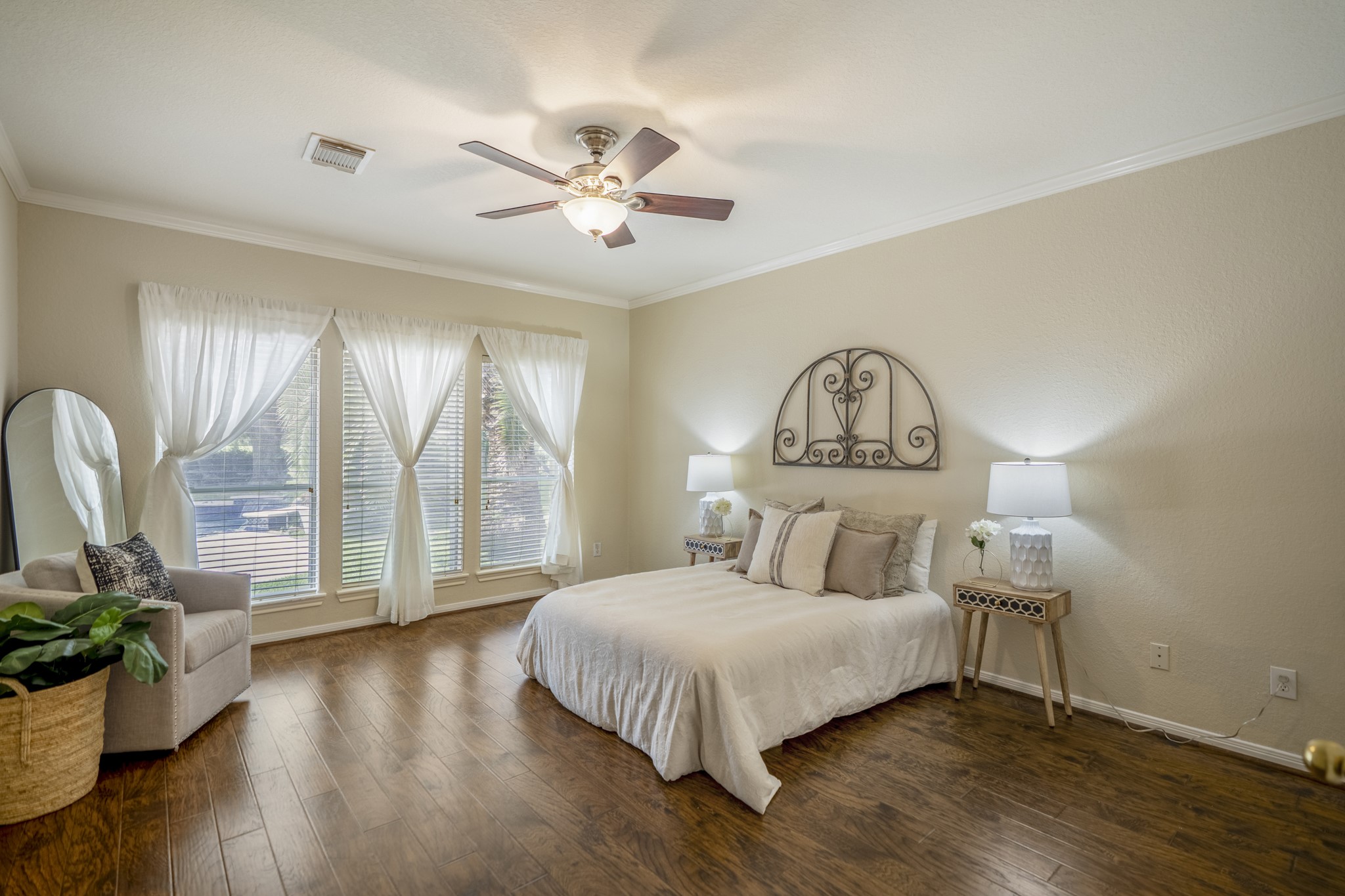 5807 Sequoia Trace Court Spring, TX 77379 - Photo 14 of 50 The downstairs primary suite offers a spacious retreat with laminate flooring, crown molding, and tall windows that bring in soft natural light while keeping the backyard and Windrose lifestyle close by.