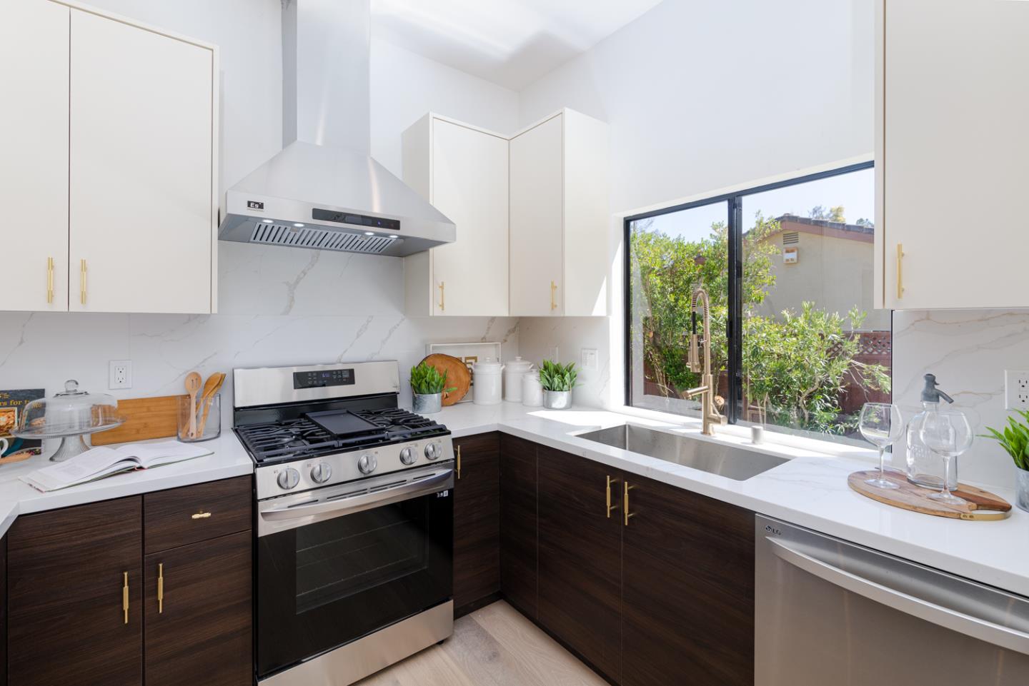 a kitchen with stainless steel appliances a sink a stove and a window