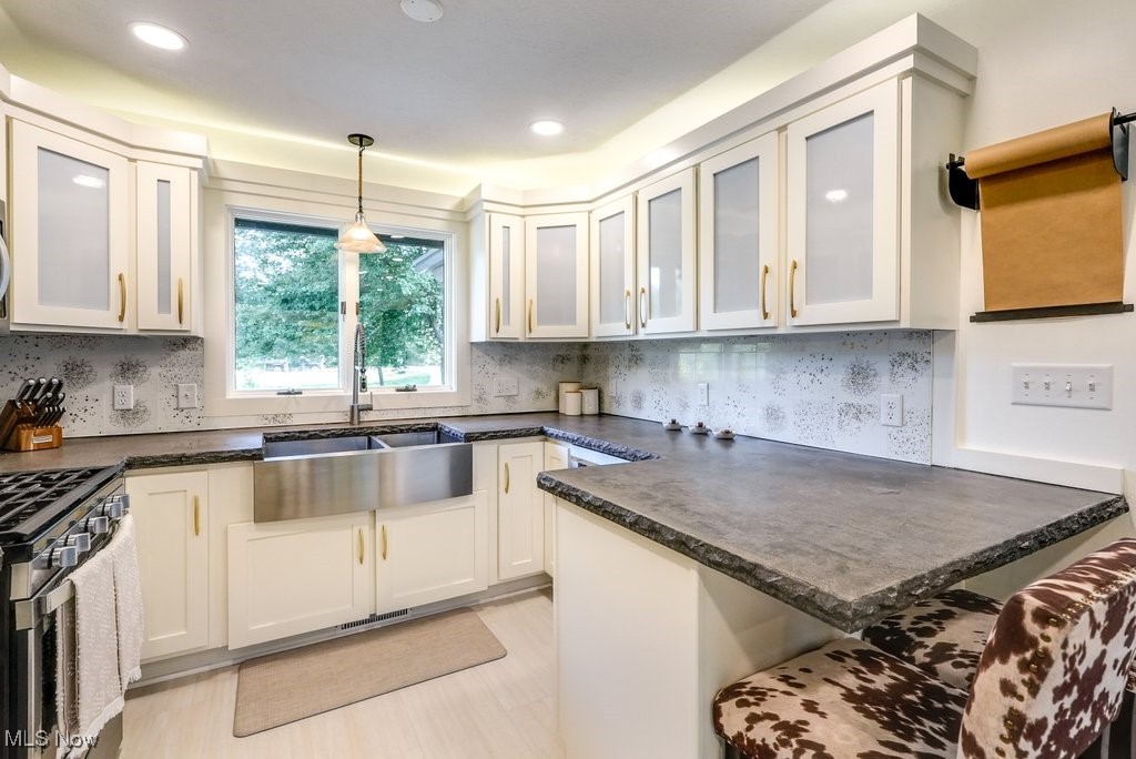 1598 Graham Road Silver Lake, OH 44224 - Photo 25 of 46 Kitchen featuring pendant lighting, high end stainless steel range oven, sink, and light hardwood / wood-style floors