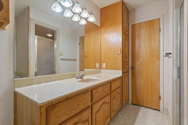 a bathroom with a sink a light fixture and a mirror