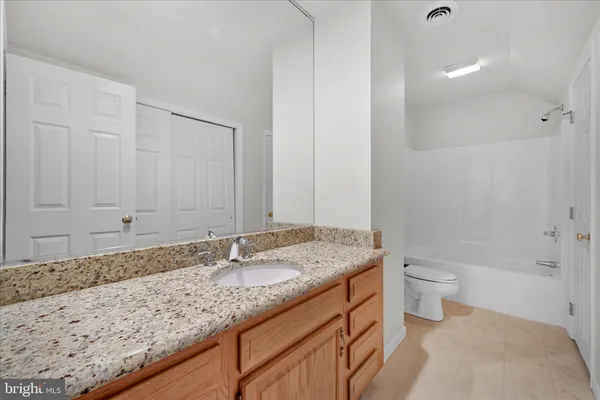 a bathroom with a granite countertop sink a toilet and shower