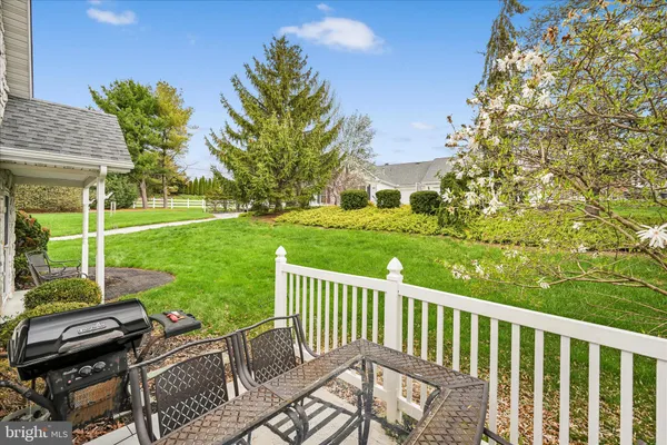 a view of a wooden chairs and table in the garden