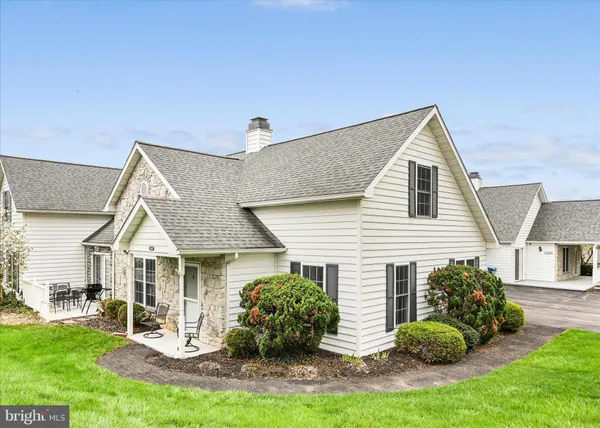a view of house with backyard and outdoor seating