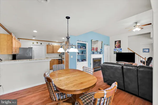 a living room with a table chairs and a dining table with wooden floor