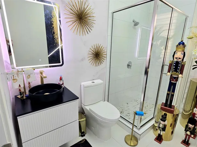 a bathroom with a sink a toilet a mirror and shower