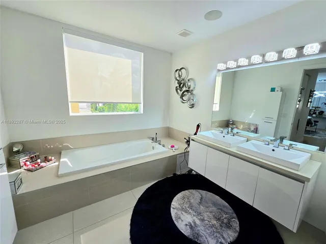 a bathroom with a tub sink and mirror