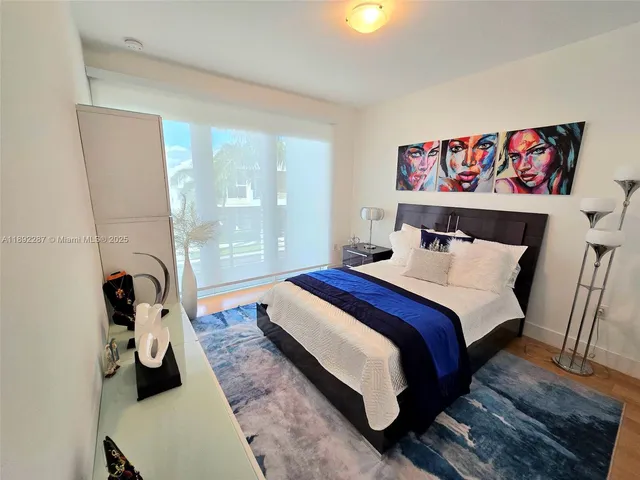 a bedroom with a bed and a painting on the wall