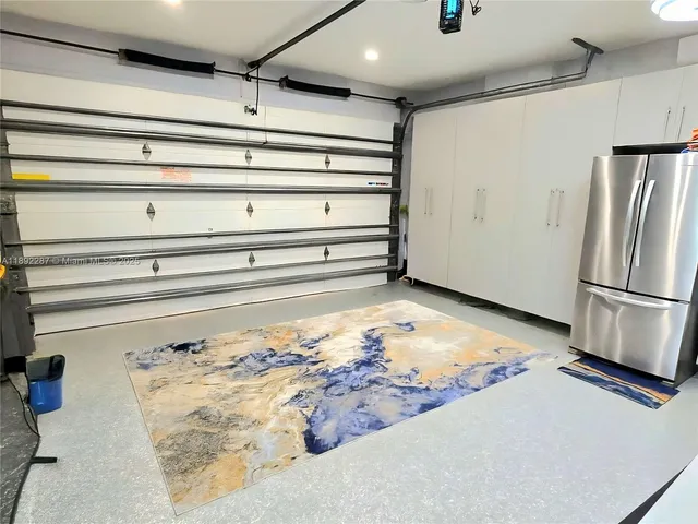 a view of a refrigerator in kitchen and an empty room