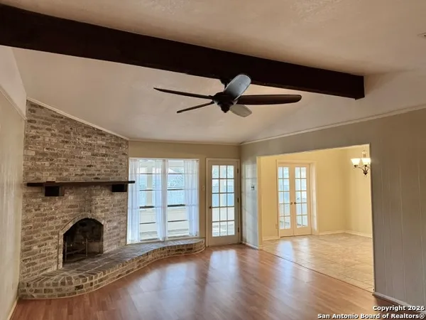 a view of an empty room with a fireplace and a window