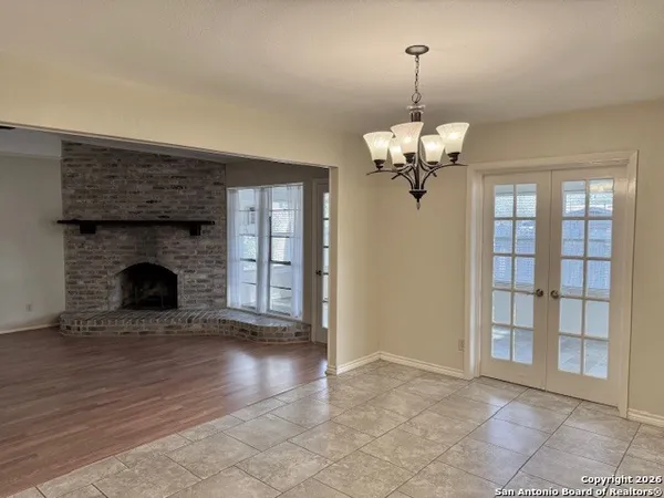 a view of a livingroom with a fireplace a chandelier and wooden floor