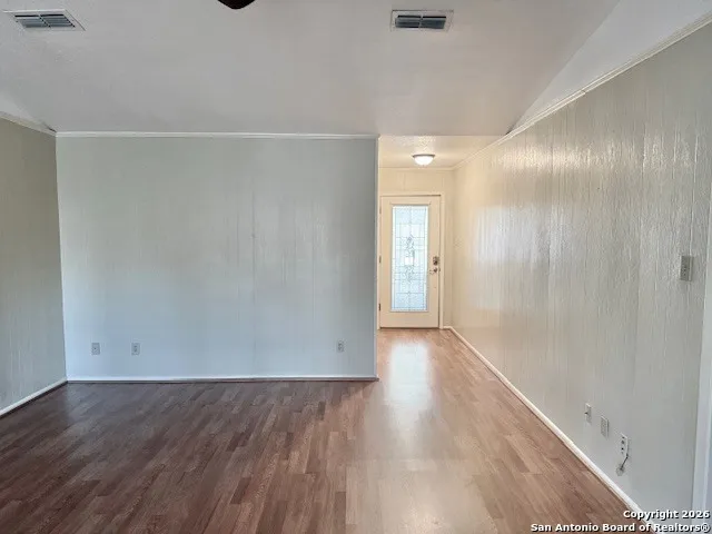 a view of an empty room with wooden floor