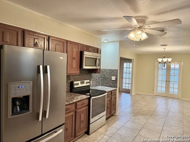 a kitchen with stainless steel appliances granite countertop a refrigerator a oven and a sink