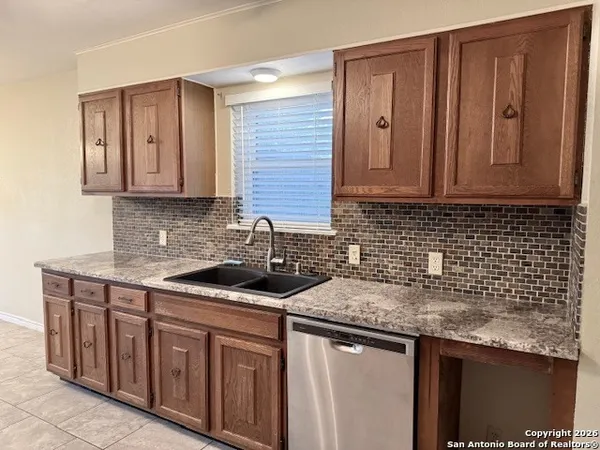 a kitchen with stainless steel appliances granite countertop a sink and cabinets