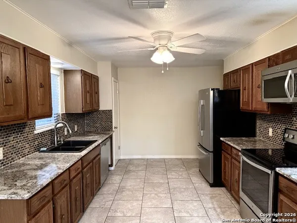 a kitchen with stainless steel appliances granite countertop a sink stove and refrigerator