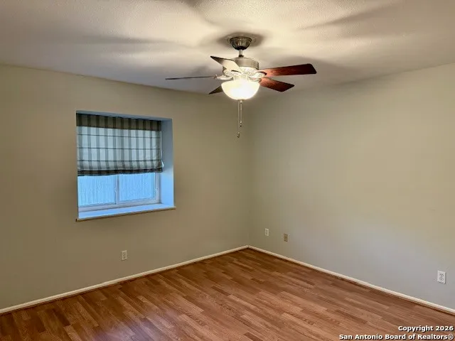 a view of a room with a fan and wooden floor