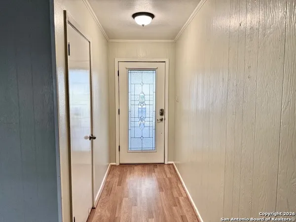 a view of a hallway with wooden floor and a bathroom