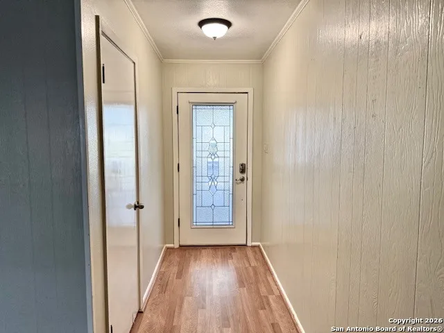 a view of a hallway with wooden floor and a bathroom
