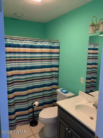 a bathroom with a sink a toilet and chair