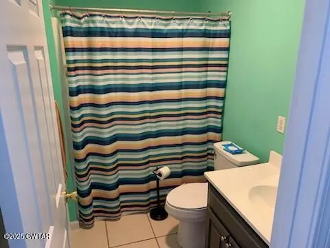 a bathroom with a sink a toilet and shower curtain