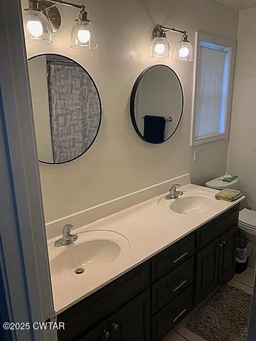 a bathroom with a double vanity sink and a mirror