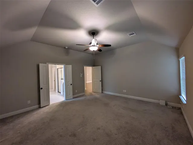 an empty room with a ceiling fan and window