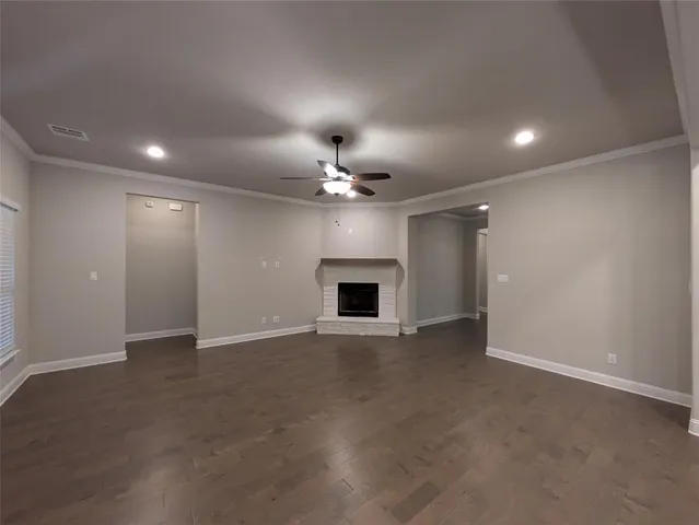 an empty room with a ceiling fan and a fireplace