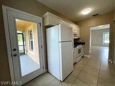 a kitchen with granite countertop white cabinets and a stove