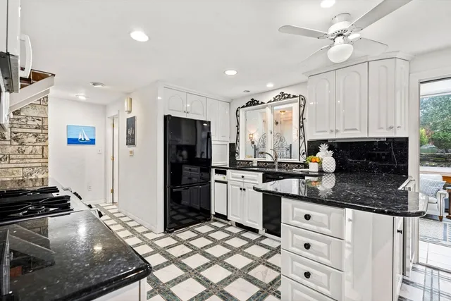 a kitchen with kitchen island granite countertop a stove cabinets and refrigerator