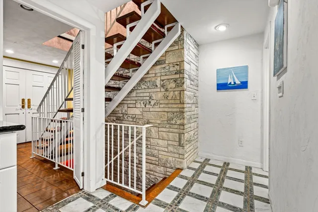 a view of staircase with wooden floor and white walls