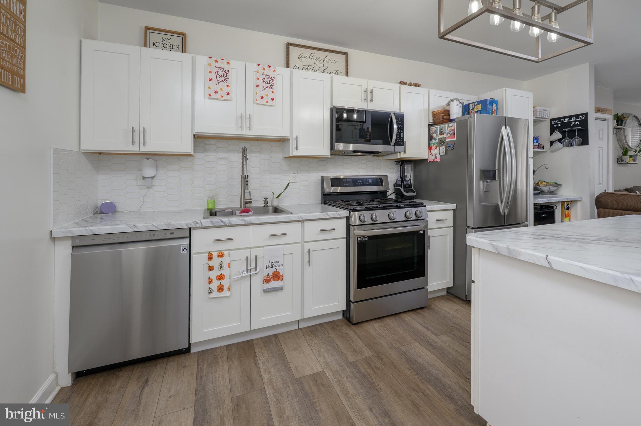 103 Middlesex Street Gloucester City, NJ 08030 - Photo 7 of 31 a kitchen with stainless steel appliances white cabinets a sink a stove a refrigerator and microwave