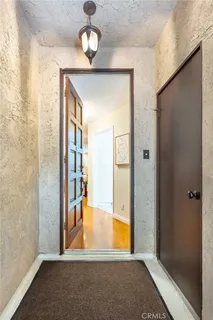 a view of a room with wooden floor and a bathroom