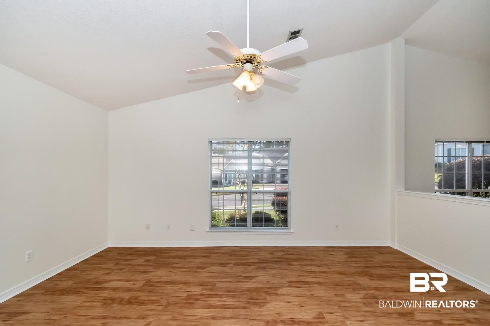 672 Spring Lake Drive East Mobile, AL 36695 - Photo 23 of 26 Empty room featuring lofted ceiling, wood finished floors, and a wealth of natural light
